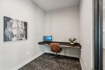 A room with a desk and a painting on the wall